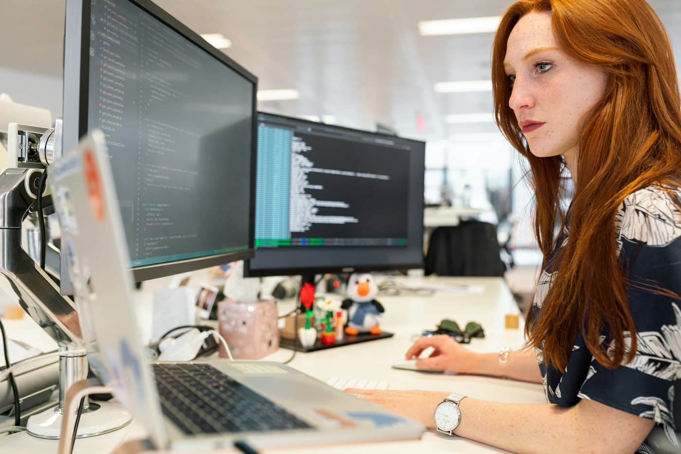 Developer coding at a dual-monitor desk